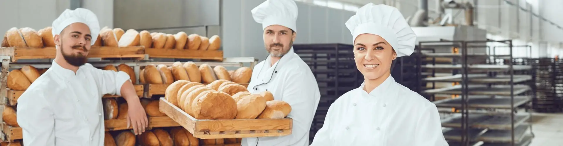 Drei Bäcker präsentieren frisch gebackenes Brot
