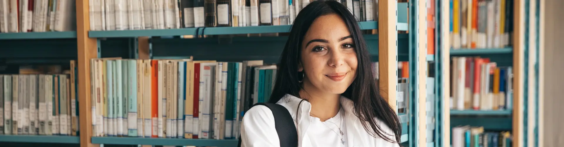 Studentin steht in der Bibliothek