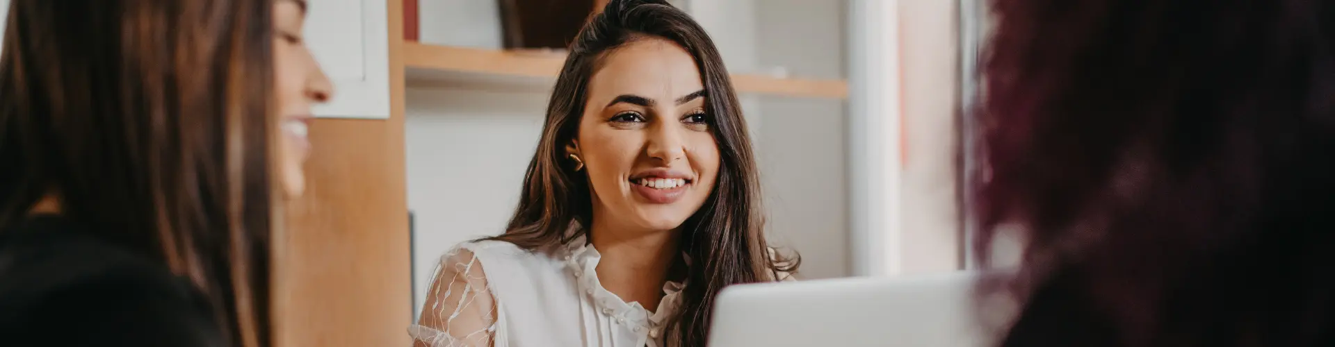 Studentin im dualen Marketingstudium arbeitet lächelnd am PC