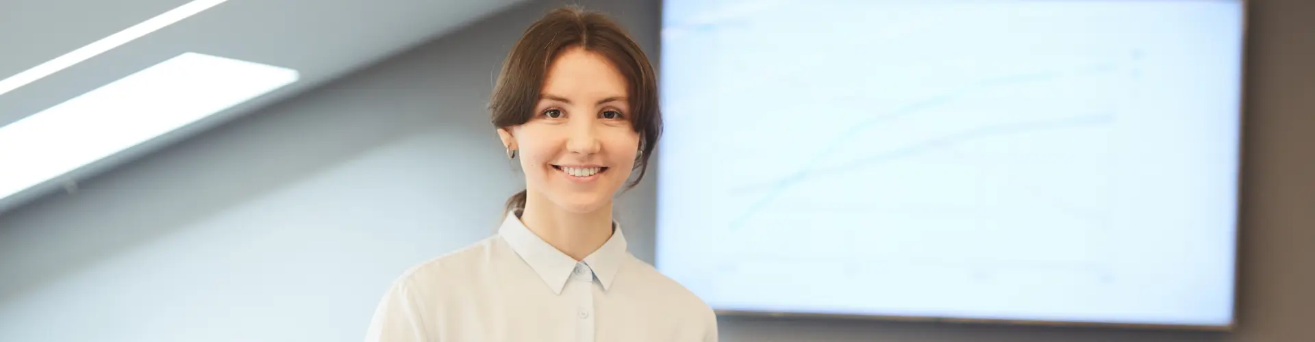 Studentin im dualen Studium Personalmanagement steht vor einem Bildschirm mit Diagramm