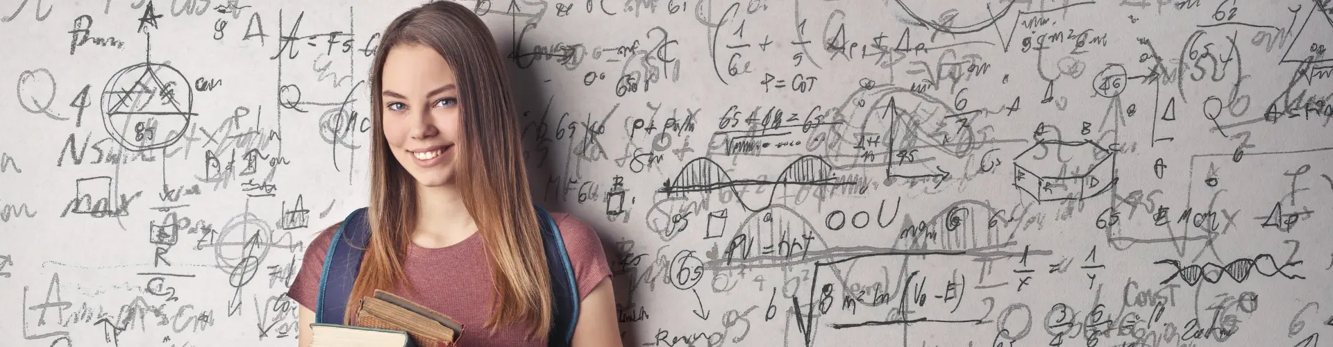 Studentin mit Büchern vor einer Wand voller physikalischer Formeln und Skizzen