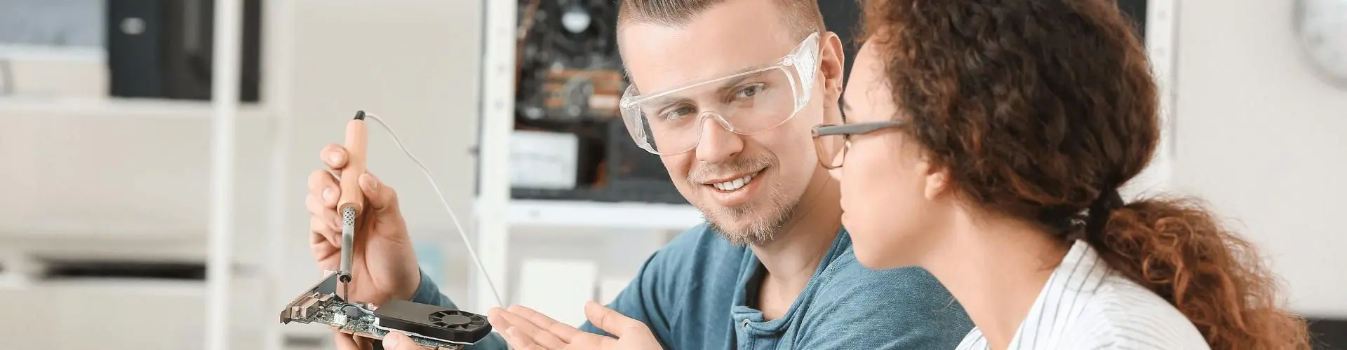 Ein junger Mann und eine junge Frau arbeiten an einem elektronischen Element