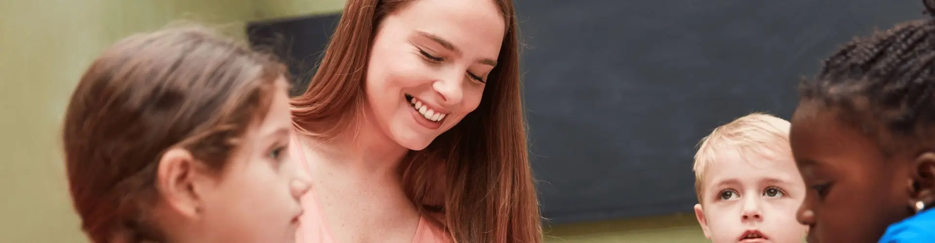 Erzieherin kümmert sich um Kinder und liest ein Buch vor