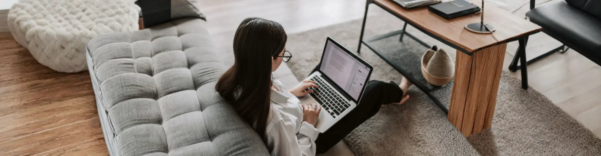 Das Bild zeigt eine Frau, die alleine und zurückgezogen am Laptop arbeitet – es steht für introvertiertes und konzentriertes Arbeiten.