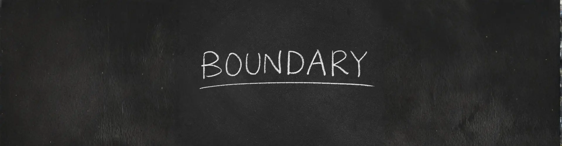 Das Wort Grenzen steht auf Englisch auf einer Tafel.