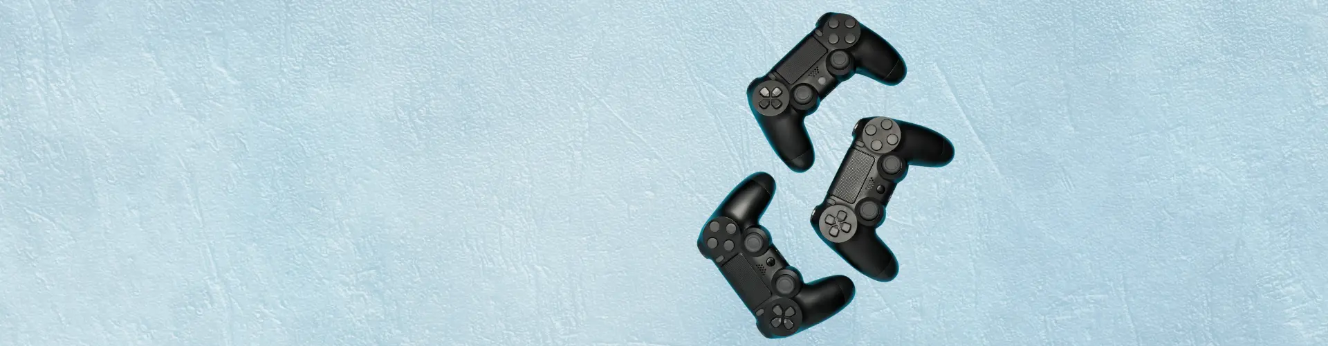 Das Bild zeigt drei schwarze Spiel-Controller auf hellblauem Hintergrund – es steht für Gaming oder gemeinsames Spielen.