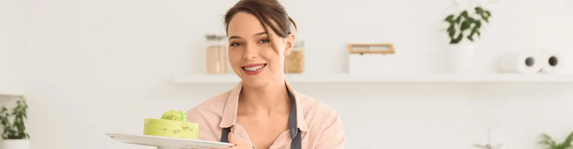 Junge Frau hält Kuchen in die Kamera