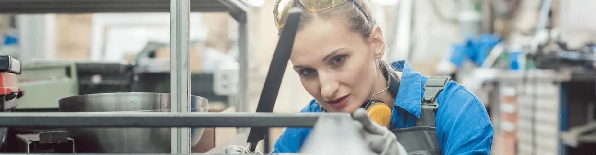 Junge Frau führt Arbeit an Metall aus