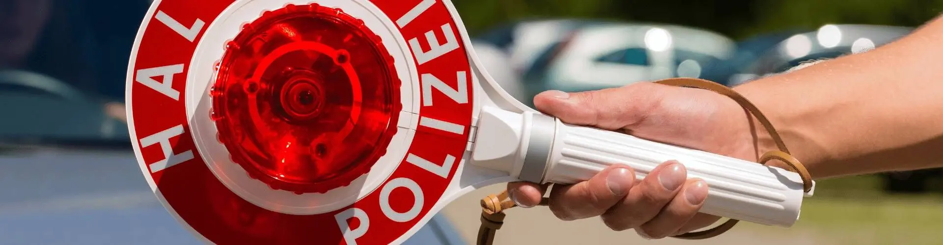 Polizeikelle mit Fahrzeugen im Hintergrund