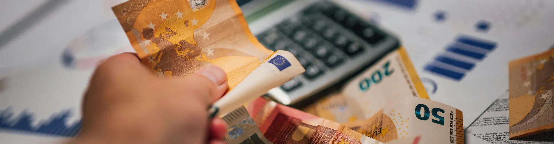 Schreibtisch auf dem Geld und ein Taschenrechner liegt