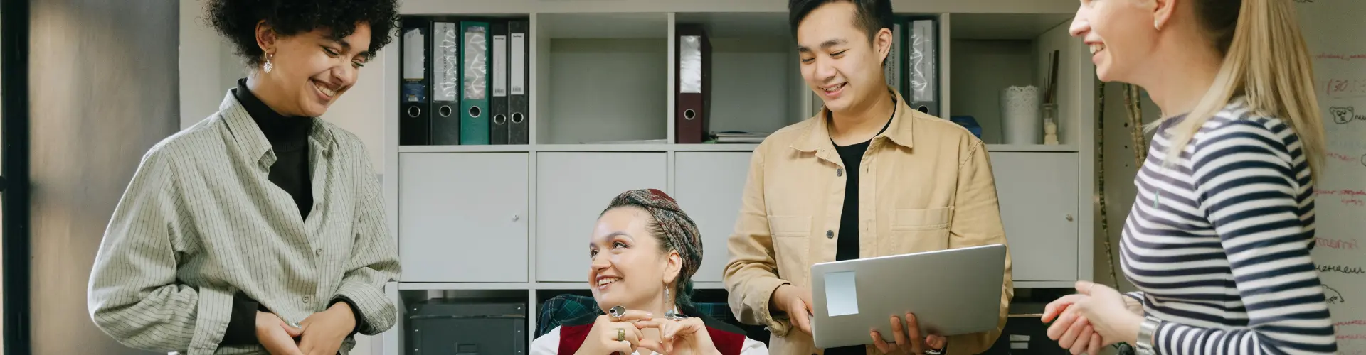 Vier Personen im büro die zusammen lachen