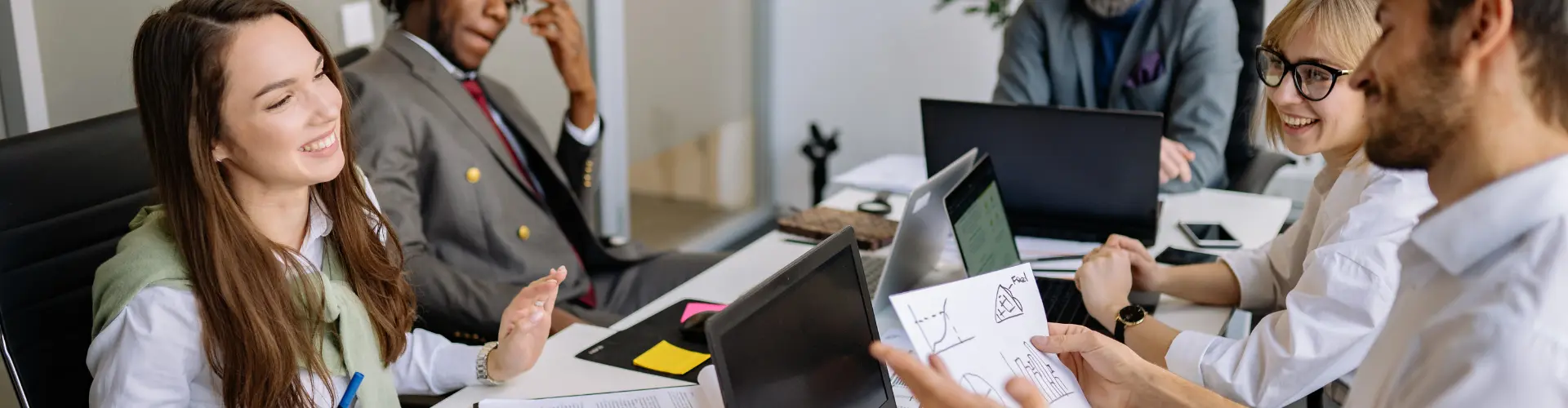 junge Personen sitzen zusammen am Tisch und besprechen sich