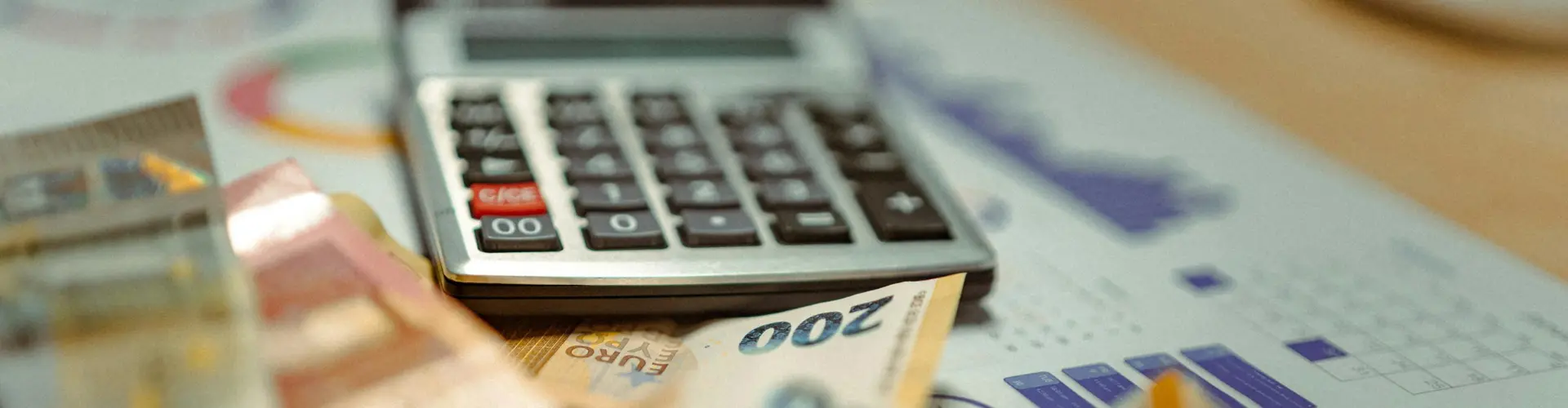 Geld und ein Taschenrechner auf einem Tisch