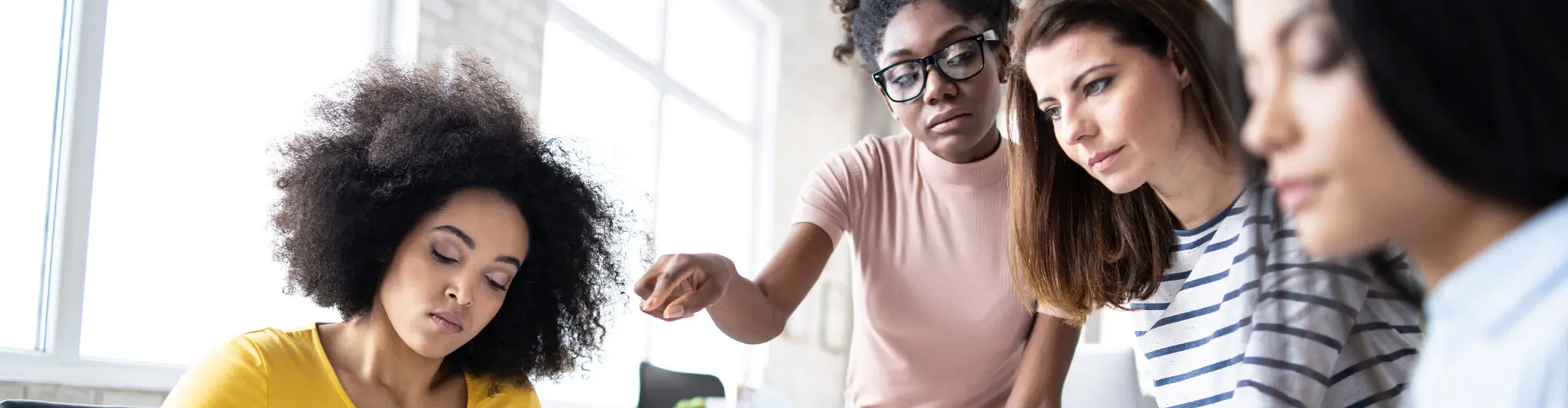 junge Menschen sitzen zusammen an einem Tisch und überlegen zusammen