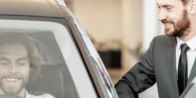 Automobilkaufmann berät Interessenten beim Kauf eines Autos