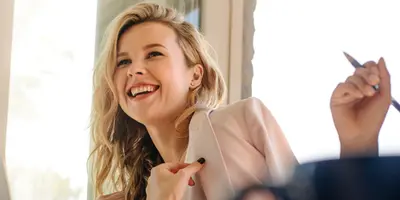 Fau im dualen Studium Mediendesign sitzt mit Person lächelnd am Tisch