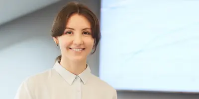 Studentin im dualen Studium Personalmanagement steht vor einem Bildschirm mit Diagramm