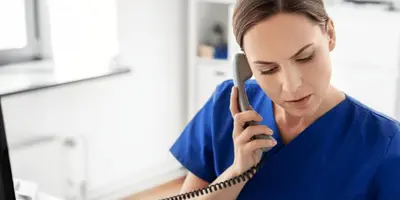 Kauffrau im Gesundheitswesen telefoniert und arbeitet an einem PC