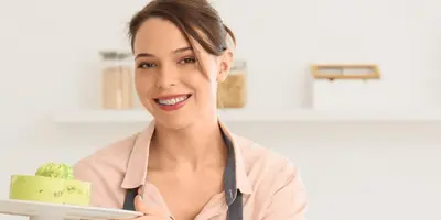 Junge Frau hält Kuchen in die Kamera