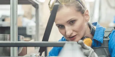 Junge Frau führt Arbeit an Metall aus