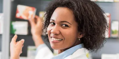 Pharmazeutisch-kaufmännische Angestellte berät in einer Apotheke