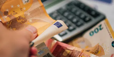 Schreibtisch auf dem Geld und ein Taschenrechner liegt