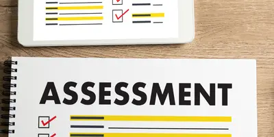 Block mit der Aufschrift "Assessment" und eine Brille