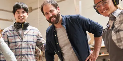 4 Personen stehend lächelnd nebeneinander