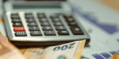 Geld und ein Taschenrechner auf einem Tisch