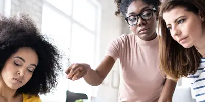 junge Menschen sitzen zusammen an einem Tisch und überlegen zusammen