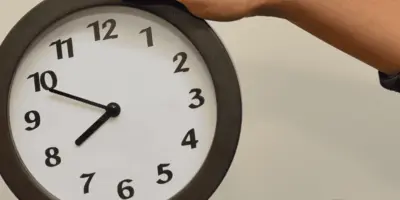 Eine Person hält eine große Uhr in den Händen