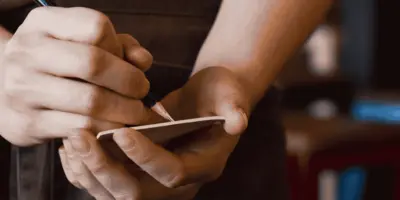 Fachkraft in der Gastronomie notiert eine Bestellung